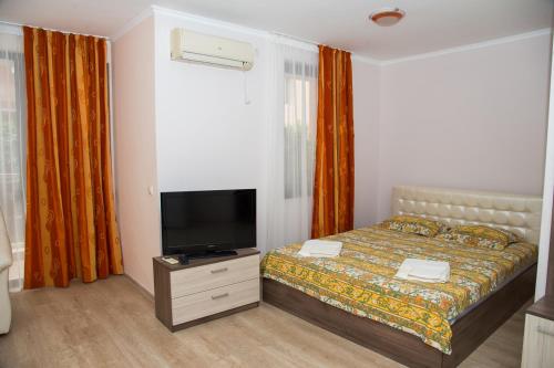a bedroom with a bed and a flat screen tv at Apart Lev in Ravda