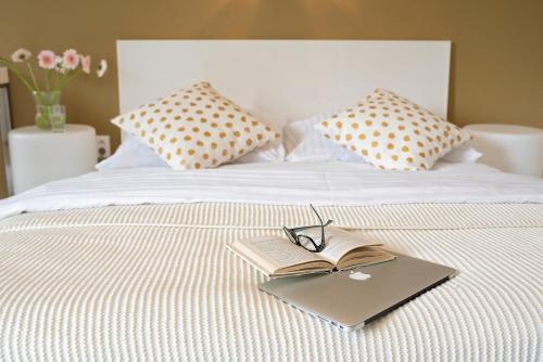książka i okulary na łóżku w obiekcie Modrý Dom w mieście Spišské Bystré