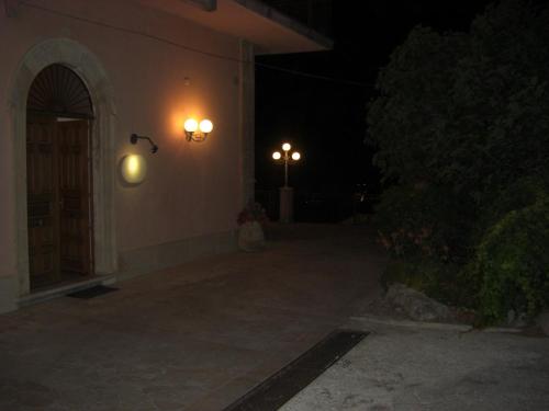 two lights on the side of a building at night at Albergo Villa Nobile in Chiaramonte Gulfi