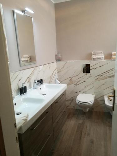 a bathroom with a sink and a toilet and a mirror at Alberta in Bertiolo