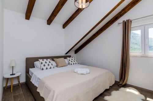 1 dormitorio con 1 cama en una habitación con paredes blancas en King Suite, en Mlini