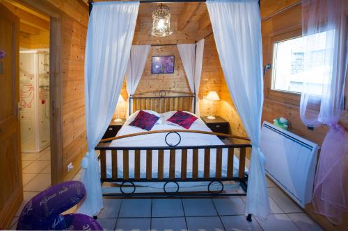 a bedroom with a bed in a wooden house at le chalet du roc in La Panouse
