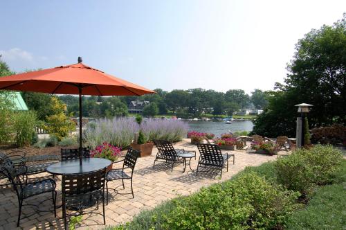 a patio with a table and chairs and an umbrella at Lake Pointe Inn in McHenry