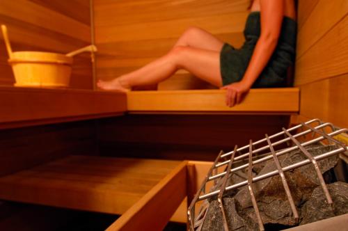 a woman sitting on a shelf in a sauna at Lake Pointe Inn in McHenry
