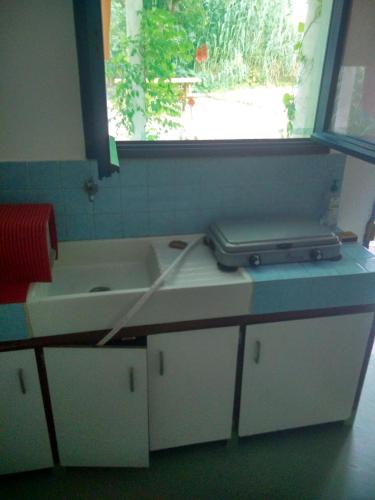 - un comptoir de cuisine avec un évier et un ordinateur portable dans l'établissement Les Bambous, camping naturiste, sur l'Île du Levant