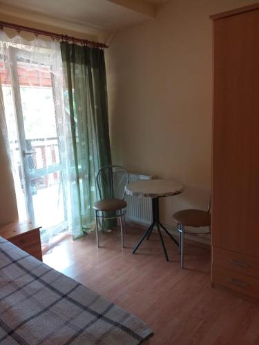 a bedroom with a table and chairs and a window at Zawojka in Zawoja