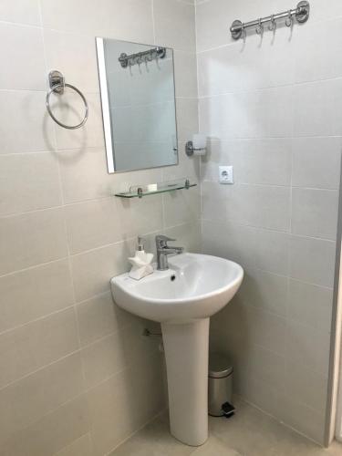 a bathroom with a sink and a mirror at Hotel CHARLI in Gonio