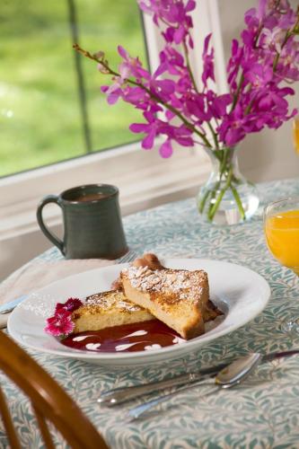 a plate of toast on a table with a vase of flowers at Lake Pointe Inn in McHenry