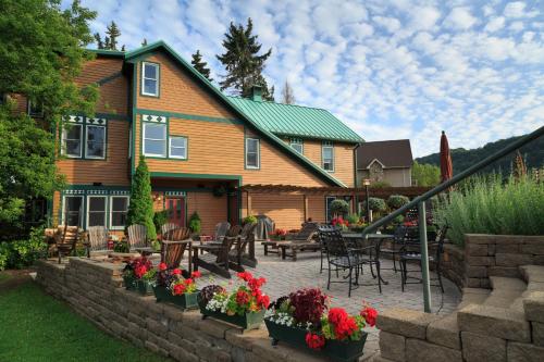 a house with a patio with tables and chairs and flowers at Lake Pointe Inn in McHenry