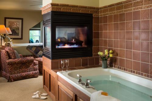 a bathroom with a bath tub with a fireplace at Lake Pointe Inn in McHenry