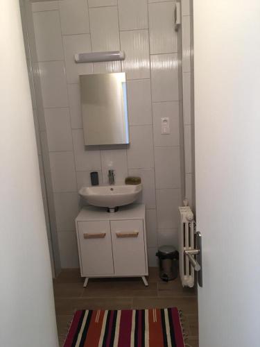 une salle de bain avec un lavabo blanc et un miroir dans l'établissement Appartement tout confort à 10 minutes de paris, à Bagneux