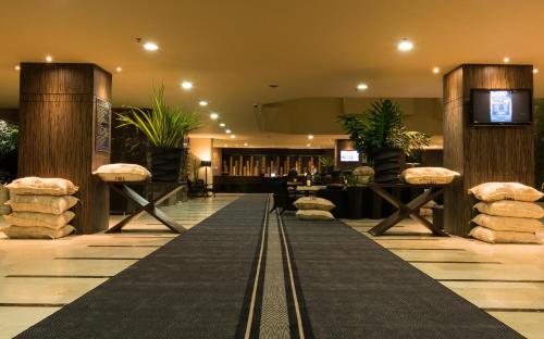 a lobby with a black carpet and a bar at Movich Hotel de Pereira in Pereira