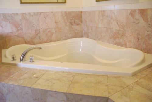 a bath tub with a faucet in a bathroom at Raritan Hotel in Edison