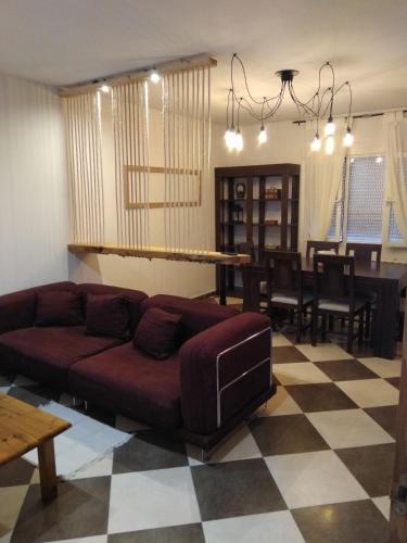 a living room with a couch and a dining room at Casa Rural el Reencuentro "Grupo Mirando a Gredos" in Cadalso de los Vidrios