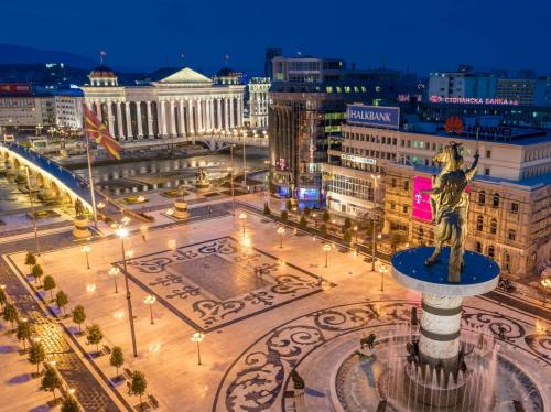 a view of a city at night with a statue at Hotel Square in Skopje