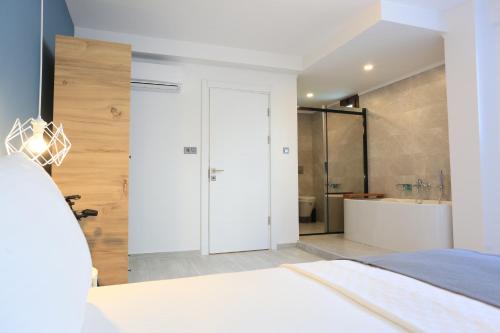 a white bedroom with a shower and a bed at Verde Suites Akyaka in Akyaka