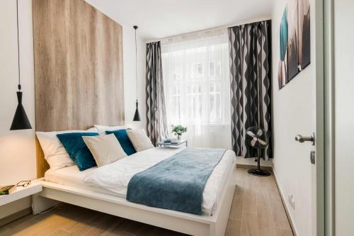 a bedroom with a large white bed with blue pillows at APT with sunny garden Prague by Michal&Friends in Prague