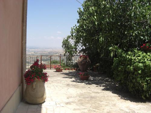 a patio with potted plants and flowers in pots at Albergo Villa Nobile in Chiaramonte Gulfi