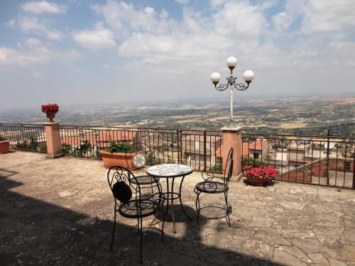 a table and chairs on a balcony with a view at Albergo Villa Nobile in Chiaramonte Gulfi