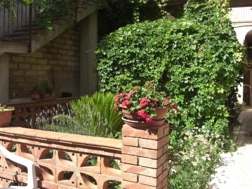 a pot of flowers on a brick wall at Albergo Villa Nobile in Chiaramonte Gulfi