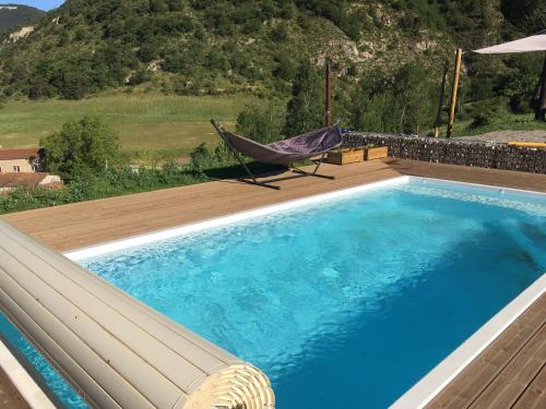 - un hamac installé sur une terrasse à côté d'une piscine dans l'établissement Villa le Tresquel, à Mostuéjouls