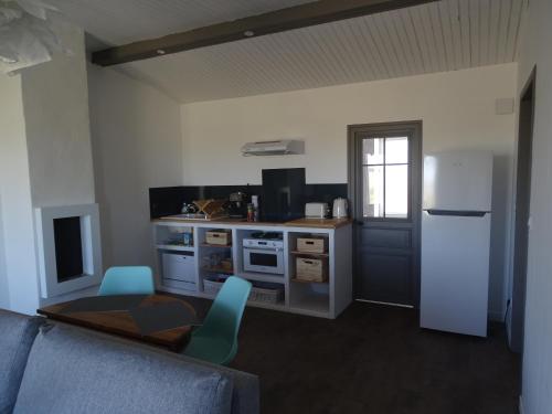 a kitchen with a refrigerator and a table and chairs at La maison de Gaston in Le Port-des-Barques