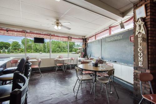 a restaurant with tables and chairs and a chalkboard at Knights Inn Amsterdam in Amsterdam