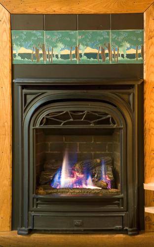 a fireplace with its door open with a fire at Lake Pointe Inn in McHenry