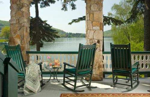 a porch with chairs and a table with a view of a lake at Lake Pointe Inn in McHenry