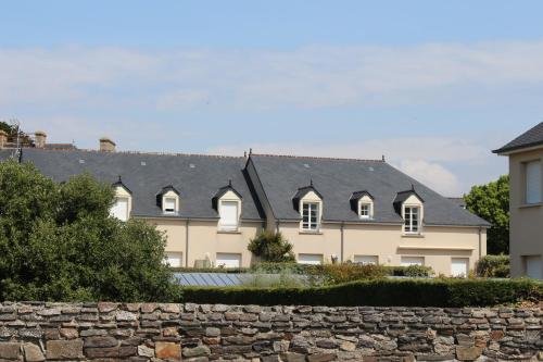 a row of houses with a stone wall at Résidence du port in Barneville-Carteret