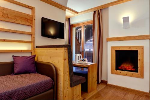a bedroom with a bed and a fireplace at Boutique Hotel Diana in Madonna di Campiglio