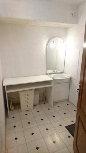 a white bathroom with a sink and a mirror at Gogo location 1 in Forest-Saint-Julien