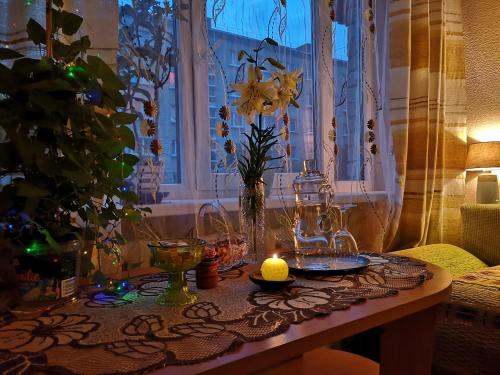 a table with a candle and vases on it at DvīņuMājas Vintage B&B in Balvi