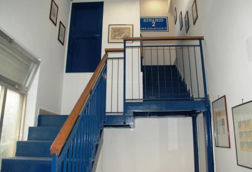 a blue staircase in a building with a sign on the wall at Binario 2 in San Giorgio a Cremano