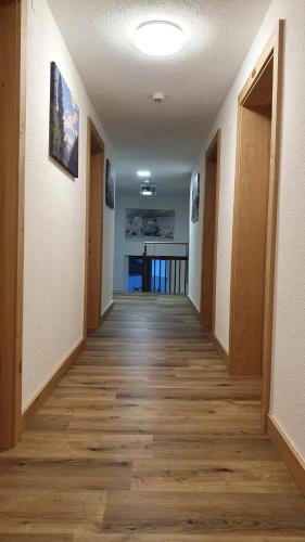 a hallway of an empty room with wood floors at Gasthof Pension Santeler in Sankt Leonhard im Pitztal