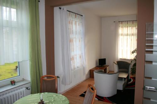 a living room with a table and some windows at Ferienwohnung am Kurpark in Bad Nenndorf