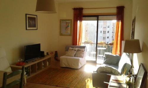 uma sala de estar com um sofá e uma televisão em apartamento no Porto