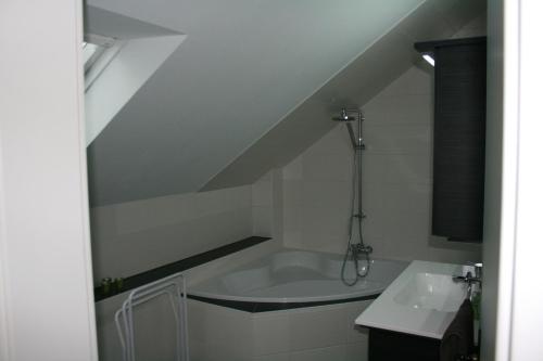 a attic bathroom with a tub and a sink at Ferienwohnung am Kurpark in Bad Nenndorf
