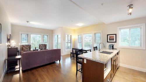 uma cozinha e sala de estar com um sofá e uma mesa em Harrison Lake View Suites em Harrison Hot Springs