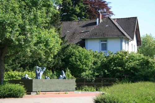 a statue in a garden with a house in the background at Ferienwohnung am Kurpark in Bad Nenndorf