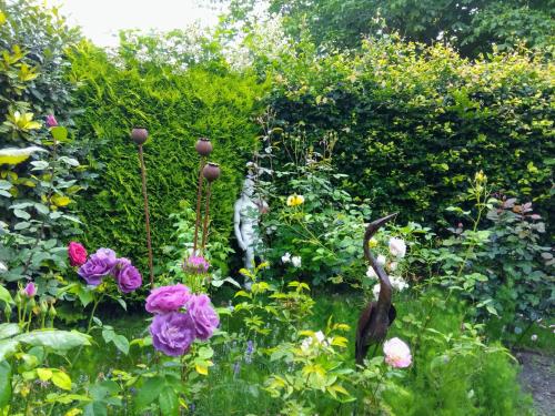 a garden with a statue of a cat and flowers at Mountain Ash in Horncastle