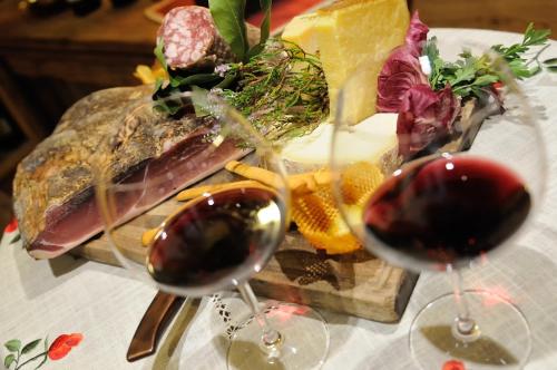 two glasses of wine on a table with food at Boutique Hotel Diana in Madonna di Campiglio