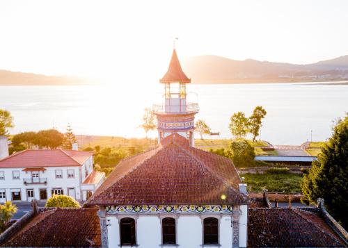 Un ancien bâtiment avec une tour en haut dans l'établissement Palacete Villa Idalina, à Caminha