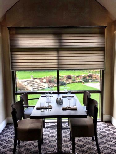 a dining room with a table and a large window at Hellaby Hall Hotel; BW Signature Collection in Hellaby