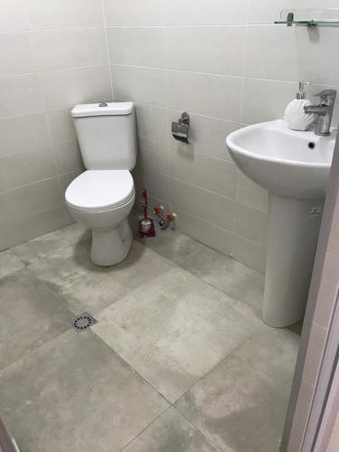 a bathroom with a toilet and a sink at Hotel CHARLI in Gonio