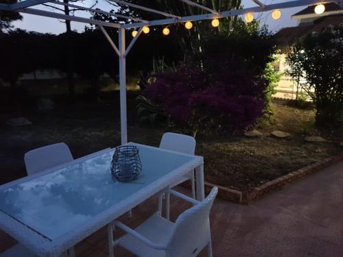 a white table and chairs in a backyard at night at La Caletta di Afrodite in Calabernardo