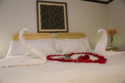 a bed with white towels and a heart made out of roses at Plaza Mayor Hotel in Puno