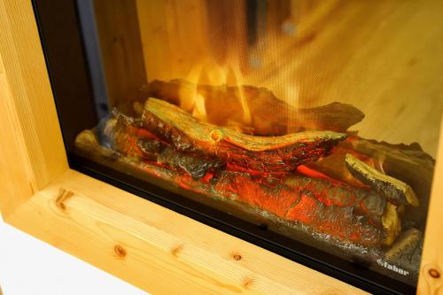 a fire in a fireplace with some food in it at Boutique Hotel Diana in Madonna di Campiglio
