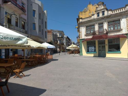 an empty street with tables and chairs and buildings at Apartament Promenada, 3 camere, langa Cazino, Faleza, Acvariu, Port Tomis, Plaja, Piata Ovidiu in Constanţa
