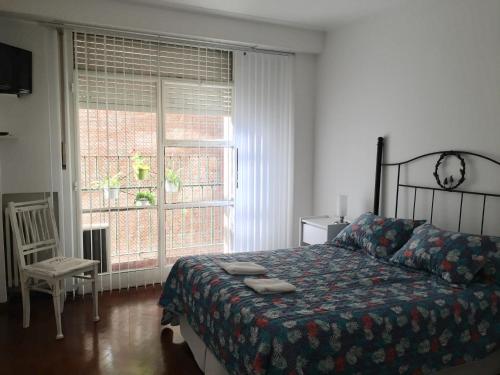 a bedroom with a bed and a large window at Brisa del Rio in Rosario